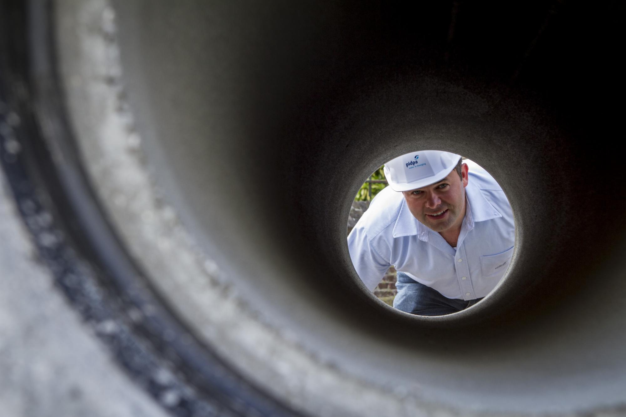 Collega kijkt door buis